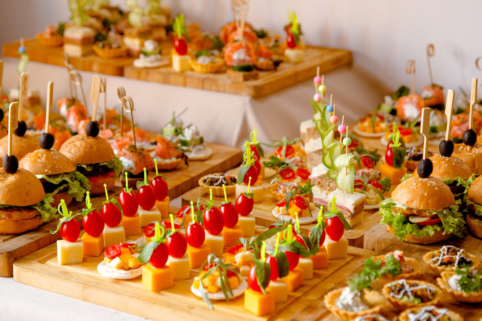buffet table with snacks from burgers cheeses etc
